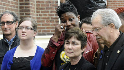 The families of slain Pittsburgh police officers Stephen Mayhle, Eric Kelly and Paul Sciullo II listen to speakers during the dedication of the sculpture of St. Michael.