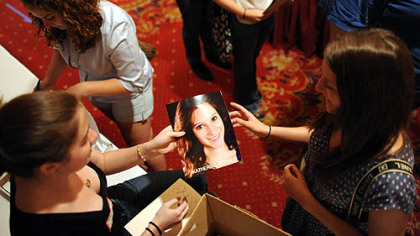 Katharine Bodner, 19, of Jefferson Hills, right, hands a profile picture over to Pittsburgh Film Office intern Claire Dempsey on Sunday as hundreds of people attend a casting session for "The Dark Knight Rises" at the Omni William Penn hotel, Downtown.