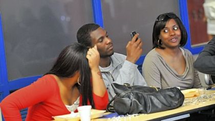 Checking photos of the McKeesport Area prom show are, from left, Jantell Morton, 16, Devon White, 18, of Woodland Hills High School, and Genise Stanford, 24.