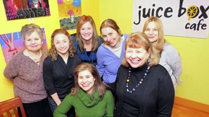 Rebecca Gilbert, seated center, with her mom, Shandel, right, and other diners at the Juice Box Cafe in Shadyside.