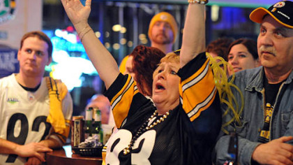 June Hough Repic raises her arms when the Steelers score.