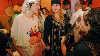 Olivia Jones (left), a University of Tennessee sophomore, and Lindsey Polansky, a Washington & Jefferson junior, check out their Middle Eastern garb with the help of Charisse Varga, a California University of Pennsylvania senior, at Khalil's II restaurant in Oakland. They were taking part in the Pittsburgh Middle East Institute's Arabic language and cultural immersion program.