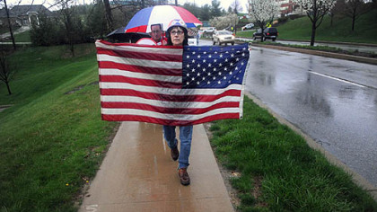 Barbara Barnes of Canonsburg holds an American flag after marching with a group of protesters gathered across the street from the Southpointe headquarters for Range Resources.