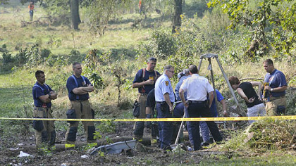 Search and rescue personnel examine a site off Washington Boulevard where a woman reportedly was swept away by Friday's flood. Her body was recovered today.