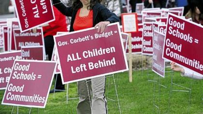 Vonnie Smid, a teacher in the Steel Valley School District for 12 years, plants signs along 22nd Street in Munhall, protesting Pennsylvania budget cuts in education.