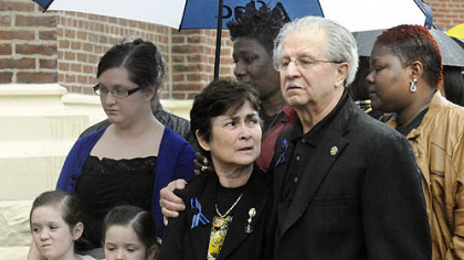 The families of slain Pittsburgh police officers Stephen Mayhle, Eric Kelly and Paul Sciullo II listen to speakers during the dedication of the sculpture of St. Michael.