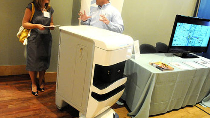 Pete Porco of Aethon promotes the company's MedEx, an advanced tracking and surveillance system, to Patti Lee, an assistant director of Career Service of CMU.