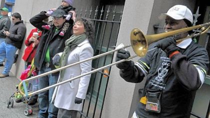 Warren Wright of Point Breeze plays his trombone on Grant Street as the St. Patrick's Day parade goes by. Behind him are, from right: Barbara Cooper of Greenville and her son Brandon Cooper of Bellevue, with his daughter Kristen Cooper, 1, on his shoulders.