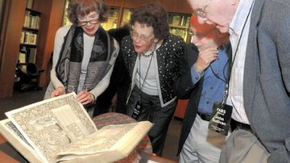 Members of the Fellowship of American Bibliophilic Societies, from left, Anne Hoy of Brooklyn, N.Y.; Mary Lane Sullivan of Cleveland; Larry Siegler of Shaker Heights, Ohio; and John Sullivan (husband of Mary Lane Sullivan) browse a book by Geoffrey Chaucer at the Hunt Library on Carnegie Mellon University campus in Oakland on Friday. The book was first printed on May 8, 1896.