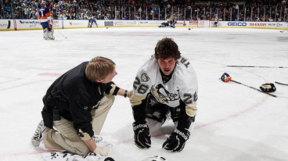 Penguins forward Eric Tangradi is tended to by athletic trainer Chris Stewart after taking a hit to the head from Islanders forward Trevor Gillies Friday at Nassau Coliseum in Uniondale, New York.