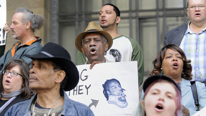 The Rev. Thomas Smith, center, of Monumental Baptist Church in the Hill District, and others chant slogans Friday at the City-County Building to protest the U.S. Justice Department decision not to file charges against police in the Jordan Miles case. The Alliance for Police Accountability plans to continue its demonstrations on Mr. Miles' behalf. Protesters called on the district attorney to press charges, demanded the police be fired and announced a protest next Saturday on the North Side.