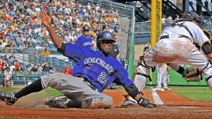 The Rockies' Dexter Fowler scores against the late tag from catcher Ryan Doumit Sunday at PNC Park.