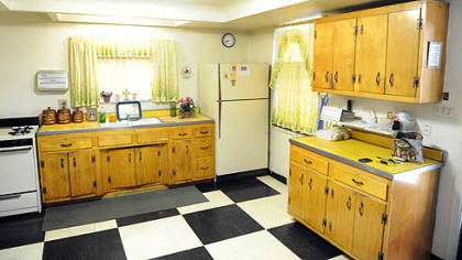 The kitchen has pine cabinetry and Formica counters installed in 1952, when the ceiling was lowered. There's a large pantry behind an elegant wood door.