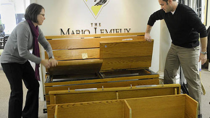 Nancy Angus, executive director of the Mario Lemieux Foundation, left, and Drew Parish, marketing manager for the foundation, pull apart the pieces of Mario Lemieux's locker on Nov. 4.