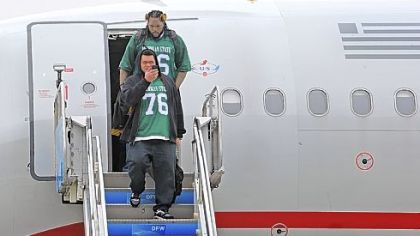 Chris Kemoeatu, foreground, and the rest of the offensive linemen -- all sporting Flozell Adams throwback jerseys from Michigan State -- exit the plane at Dallas-Fort Worth International Airport Monday. The jerseys were a tribute to Adams.