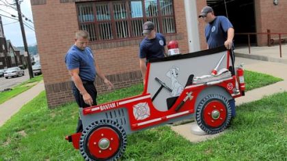 Bulter city firefighters Dean Selfridge, left, Mike Huey and Phil Rozic install a cutout jeep outside Butler's Fire Bureau in preparation for this weekend's Bantam Jeep Heritage Festival.