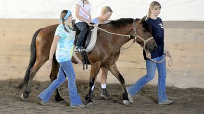 Abby Langer, 8, of Irwin rides on 6-year-old Starlight with help from Stacy Shirer, Pam Burkland and Jennifer Harbaugh at Nickers 'n Neighs.