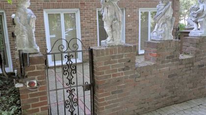 Side courtyard and gates with Angel statuary. After one of the angels was stolen a few years ago, the owner had the remaining angels cemented into place and monitored by the patio alarm system.
