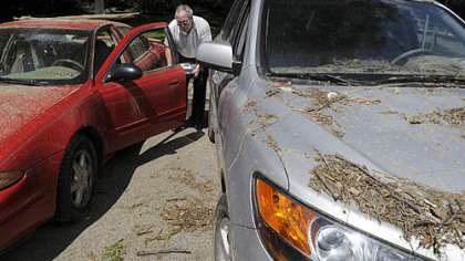 Erie Insurance Material Damage Adjustor Larry Johnson checks flood-damaged vehicles parked at the Pittsburgh Police Zone 5 parking lot on Washington Blvd. to see if his company is the insurance carrier.
