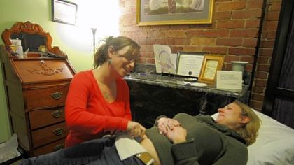 Certified nurse midwife Abigail Rizk lets Summer Arrigo-Nelson listen to her child's heartbeat during her first exam at The Midwife Center in the Strip District. Because of new changes in coverage, Mrs. Arrigo-Nelson plans to deliver her baby at the center, rather than a hospital.