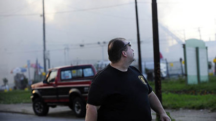 City policeman walks down Frankstown Avenue away from the fire in Larimer about two blocks away.