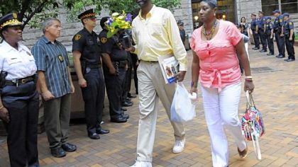 Marena Kelly, right, widow of Officer Eric G. Kelly, walks through a line of Pittsburgh police officers standing at attention after the sentencing. With her is her brother, Clarence Peays.