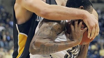 Long Beach State's Edis Dervisevic wraps up Nasir Robinson while going for the ball in the first half Saturday night at Petersen Events Center.