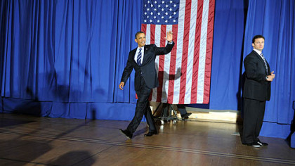 President Obama waves to the audience as he enters the hall to give a speech at the IBEW building on the South Side.