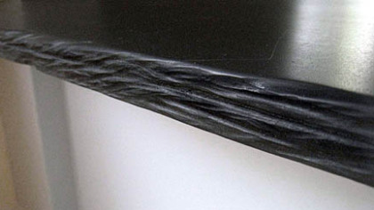 Detail show hand-carved edge of counter Isaac Bower made with old chalkboards.
