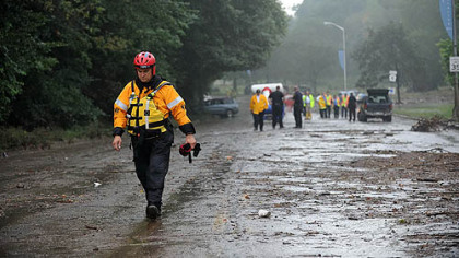 A water rescue crew memeber walks from the scene of a flash flood in August along Washington Boulevard. Four people died in a flash flood when storm drains were plugged with dirt, rock and other debris, making it impossible for water to flow freely into the city's storm sewers.