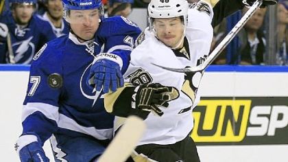 Center Tyler Kennedy and Lightning defenseman Marc-Andre Bergeron battle for a bouncing puck Thursday in Tampa, Fla.