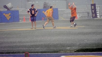 Fans dance in heavy rain at Mountaineer Field in the first of two weather delays at the West Virginia-Marshall game Sunday in Morgantown, W.Va.