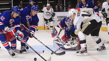 New York Rangers center Artem Anisimov (42) and Ryan McDonagh (27)  help Rangers goalie Henrik Lundqvist defend the goal as Penguins' Chris Kunitz (14) looks on.