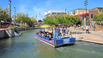 Visitors ride an excursion boat along Pueblo's Riverwalk.