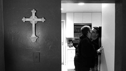 Eric Chiado and his wife, Kelly Knieling, kiss after they get home from work.