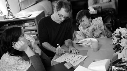 Tom Alberts is trained as a Web designer but spends most of his days taking care of his mother-in-law, Emily Gorski, who has Parkinson's disease. Here, he signs off on a visit from Medicare hospice worker Melissa Purkey, a certified nursing assistant.