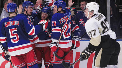 New York Rangers  celebrates a goal  Penguins' Sidney Crosby  skates past them.
