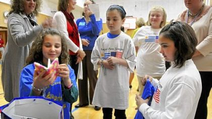 Valentina Fontora looks over gifts presented to her and Valentina Mezquida, right. Watching from behind are Courtney Walsh and Madison Maselko == their U.S. pen pals and hosts.
