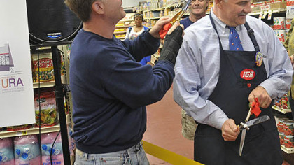 Ron Levick, left, who owns the new Beechview IGA, as well as the IGA in Oakland, gives a mock haircult to grocer Wayne Hancock, who manage the store. The scissors were used in the ribbon-cutting festivities.