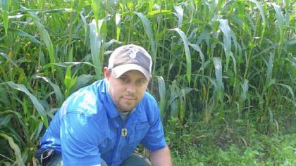 Agronomist Adam Korman checks growth at a food plot planted to enhance deer hunting.