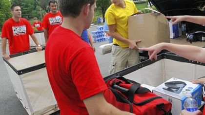 Robert Morris University freshman Jaryd Herbert, center, 18, of Cranberry, unloads his belongings last Thursday while university volunteers help at the campus in Moon.