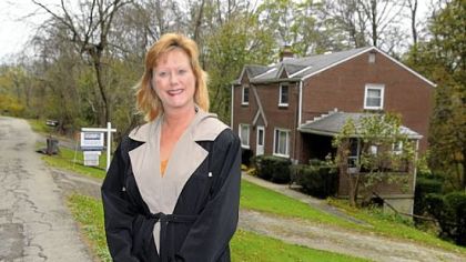 Margie Churchel with one of her listed houses in Penn Hills.