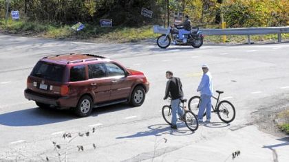 Bicyclists leaving the Montour Trail wait to cross busy Morganza Road in Cecil. A new bridge will span over Morganza Road at the intersection with Oriole Road. It should be completed in June.