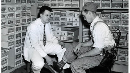 The growth of factory work created blue-collar and white-collar workforces, often in the same setting. Here, a salesman in the H.J. Heinz Co. in-house shoe store helps a worker there try on a pair of shoes in 1949.