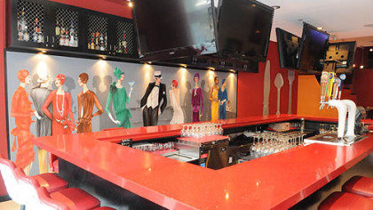 Paitned patrons lounge along one side of the bar inside.