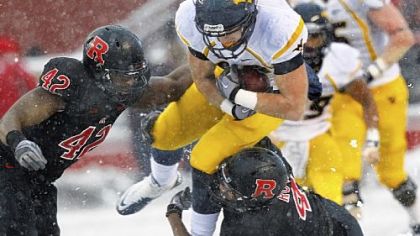 West Virginia's Tyler Urban tries to split two Rutgers defenders Saturday in the snow of Piscataway, N.J.