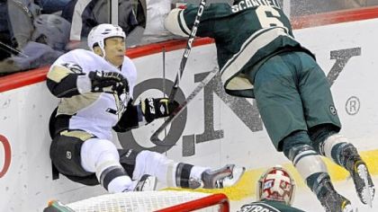 Minnesota's Marco Scandella, right, crashes into the glass after checking Richard Park.