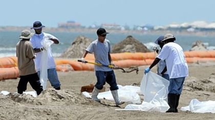 Workers gather oil from a beach in Grand Isle, La., in 2010. Oil cleanup methods hadn't changed in decades.