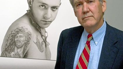Mark Perrott in front of his photograph, "Joshua, 1997", part of his exhibition, "Tattoo Witness -- Photographs by Mark Perrott", at the Westmoreland Museum of American Art.