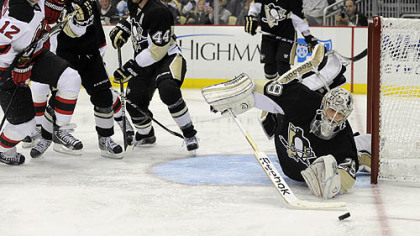 Penguins' Marc-Andre Fleury dives to knock the puck away against the Islanders.